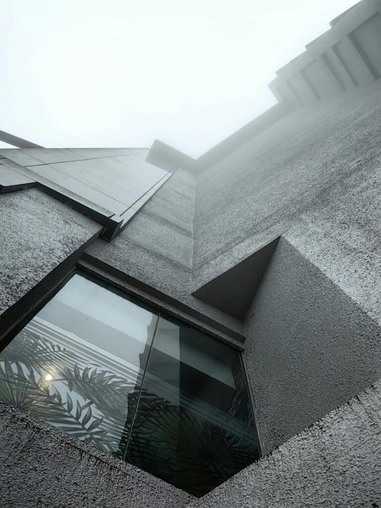 A modern concrete building facade set against a misty sky in Genting Highlands, Malaysia.